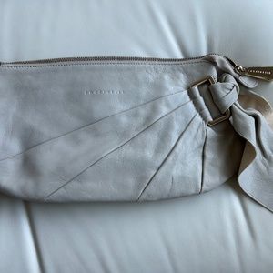 Coccinelle clutch in ivory with tie and gold hardware